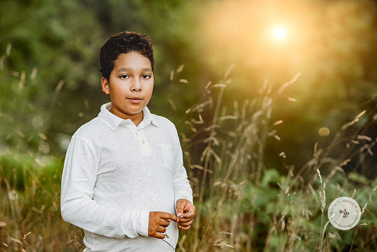 boy stands in white collared shirt during Concord MA family portrait session in the fall