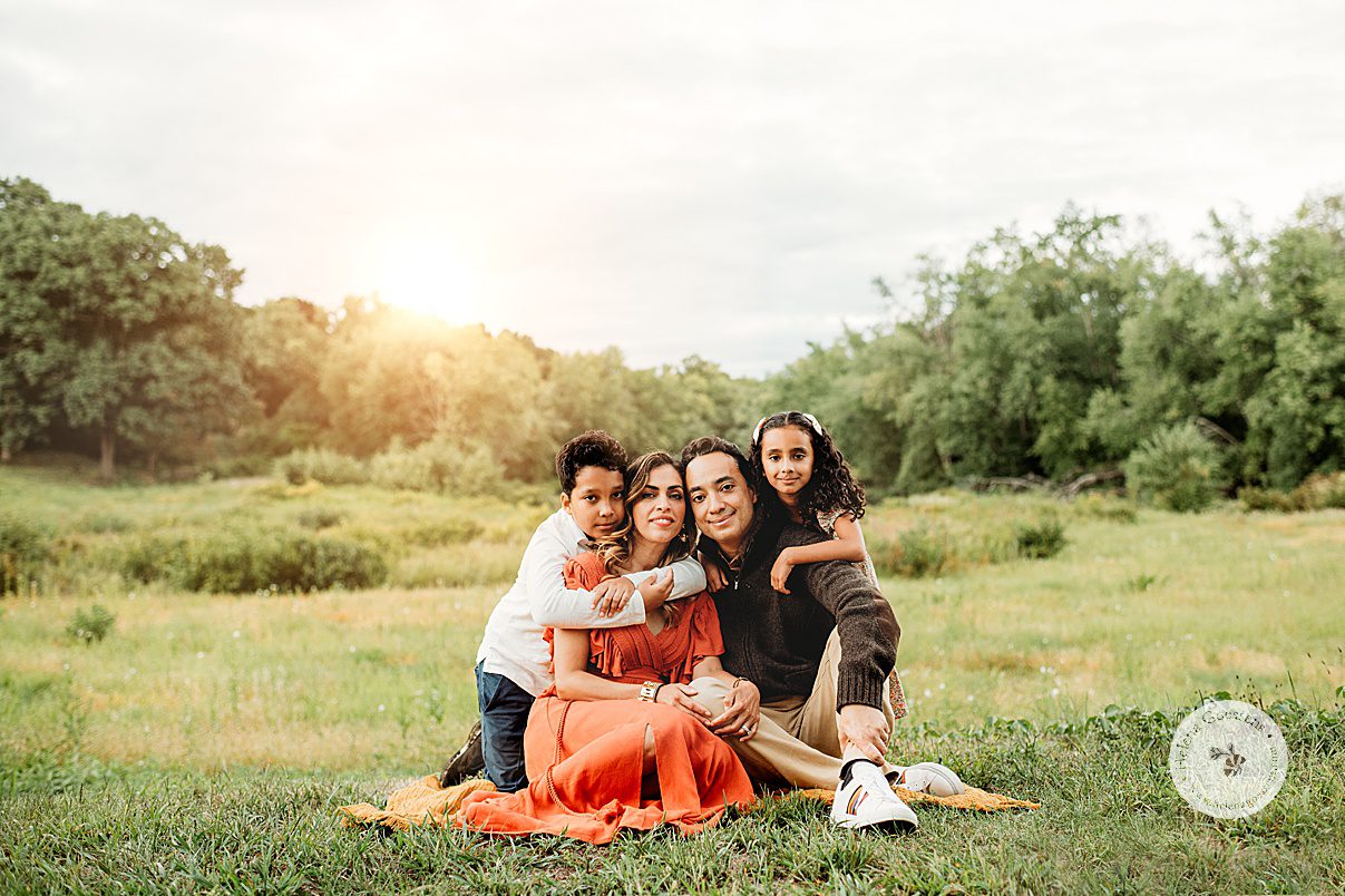 parents kneel with kids hugging them during Concord MA family portrait session in the fall