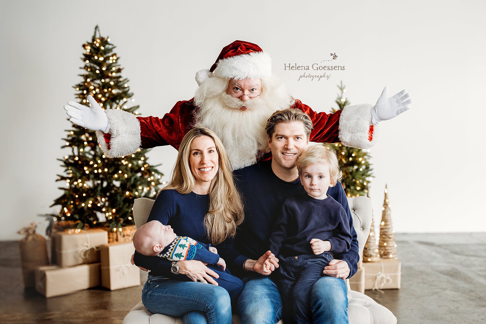 family with two boys sits in front of Santa during Studio Santa Portraits in Norwood, MA