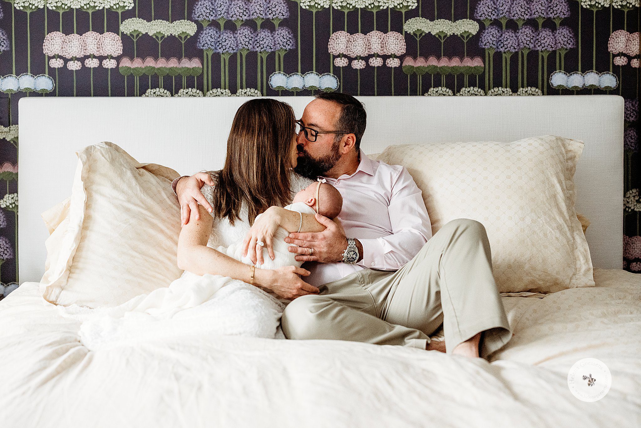 parents kiss on bed holding baby girl during Dover MA Lifestyle Newborn Session