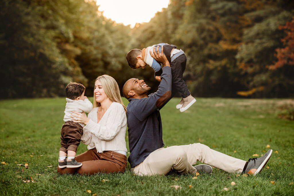 parents play with two sons during fall family photos in Boston MA
