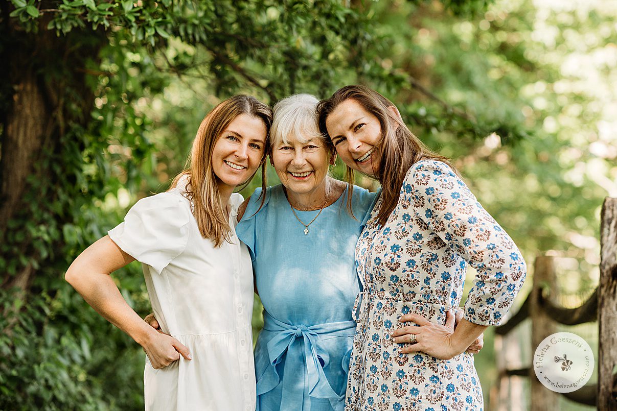 mom hugs two adult daughters next to wooden fence during Bradley Estate family photos