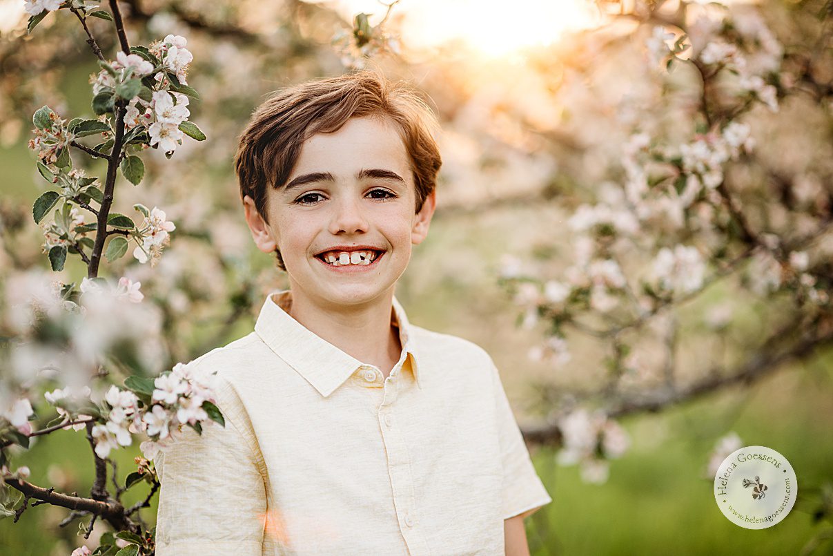 boy in yellow linen polo smiles during family photos at Arnold Arboretum