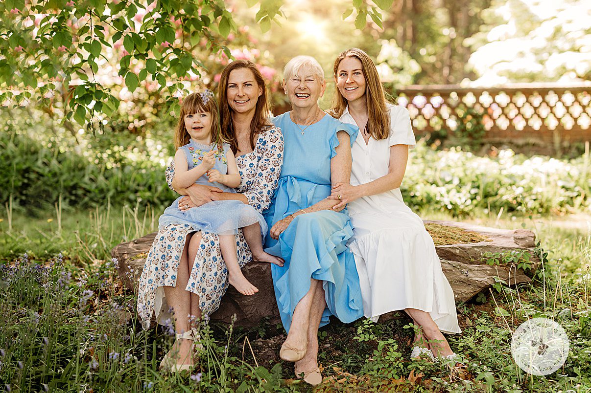 woman in blue dress sits with daughters and granddaughters during Bradley Estate family photos