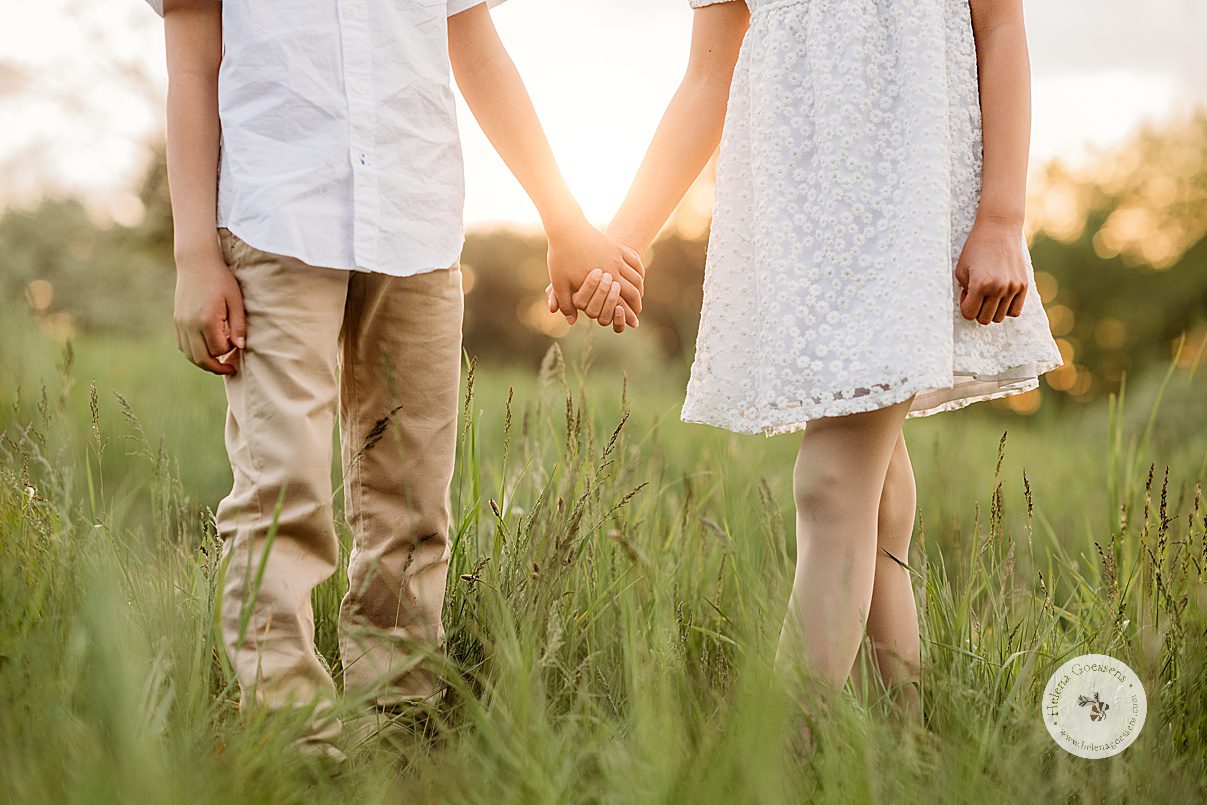 brother and sister hold hands during summer family photos