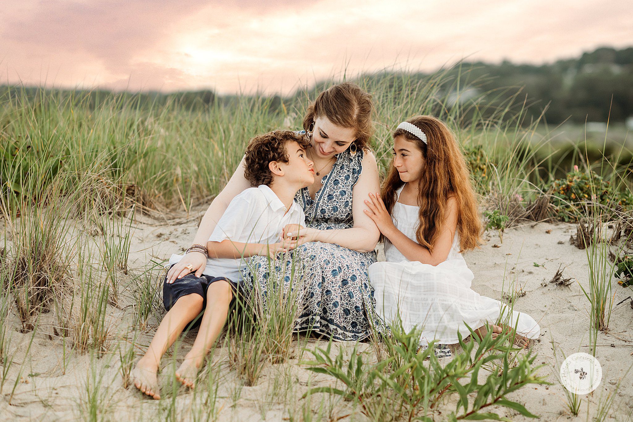 mom sits with two kids on beach during Marshfield family portraits on the beach 