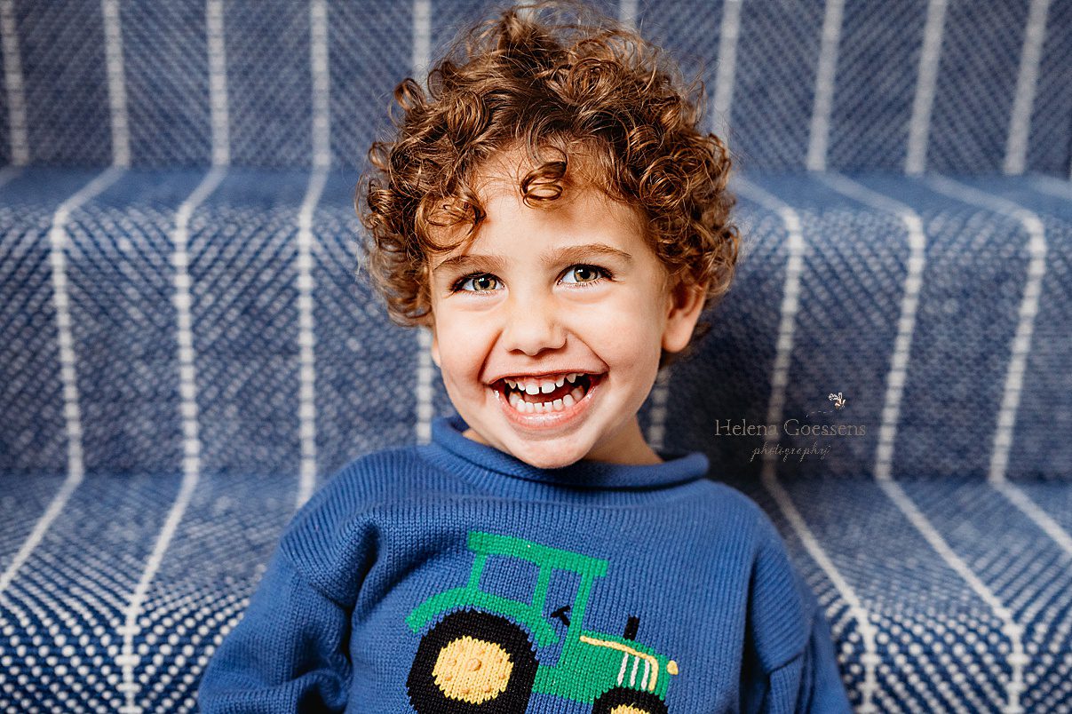 toddler in blue sweater with tractor during lifestyle family photos 