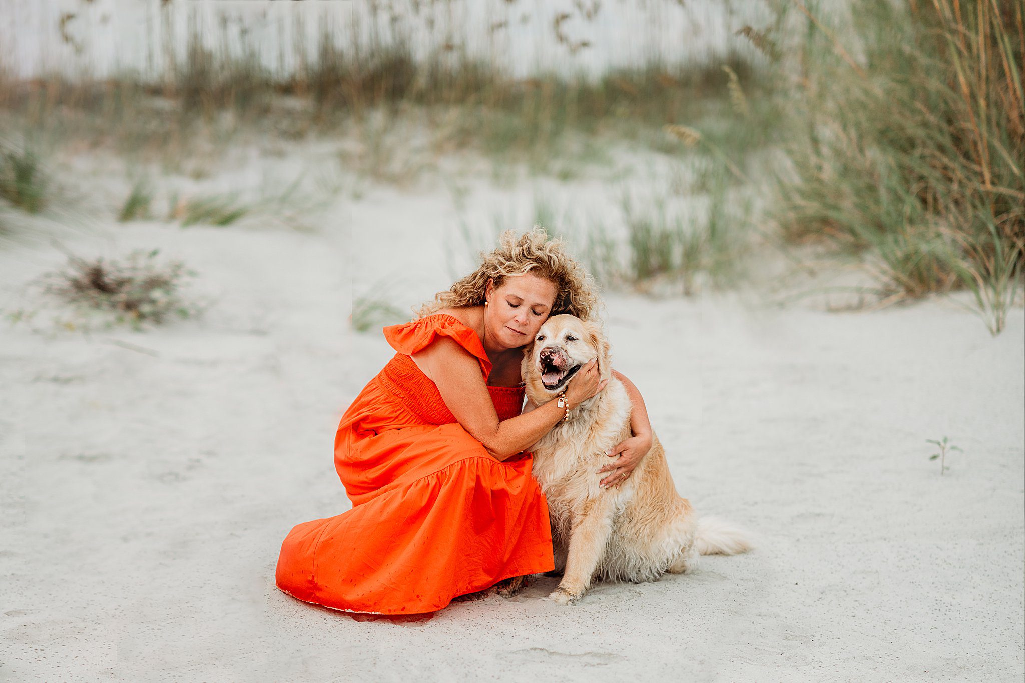 Boston Newborn and Family Photographer Helena Goessens Photography hugs golden retriever on Seabrook Island in South Carolina 