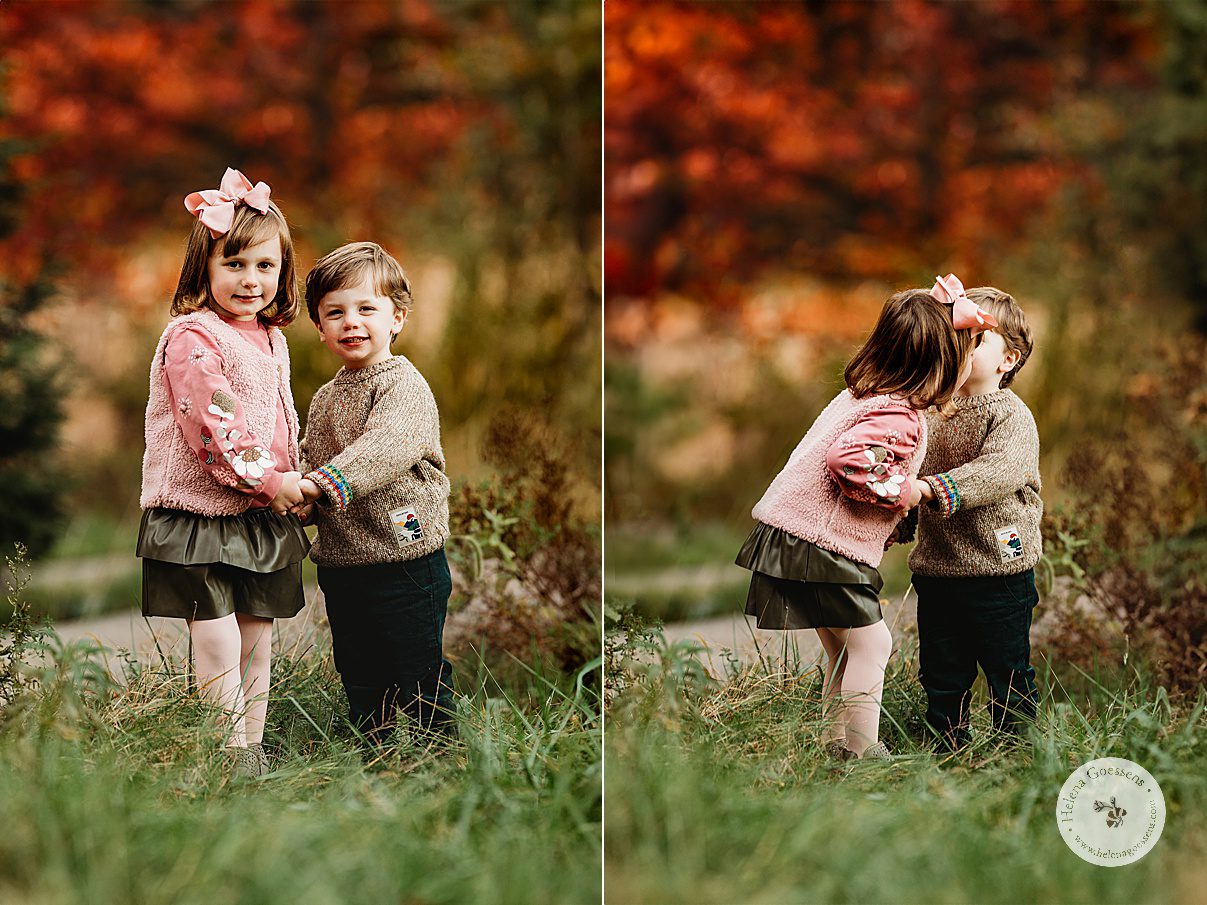 toddler boy and girl hold hands on hill during fall family portraits at Wellesley College