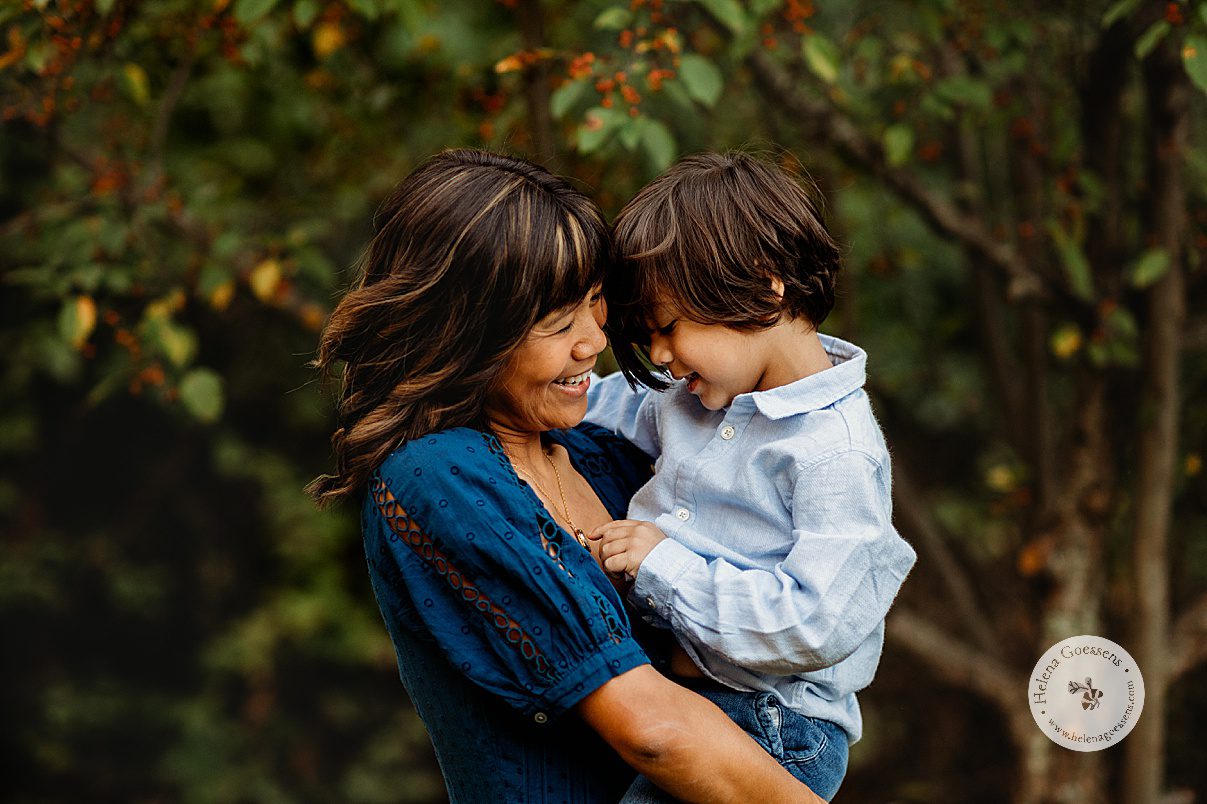 mom hugs son smiling and laughing in backyard during family portraits at home in Dedham MA