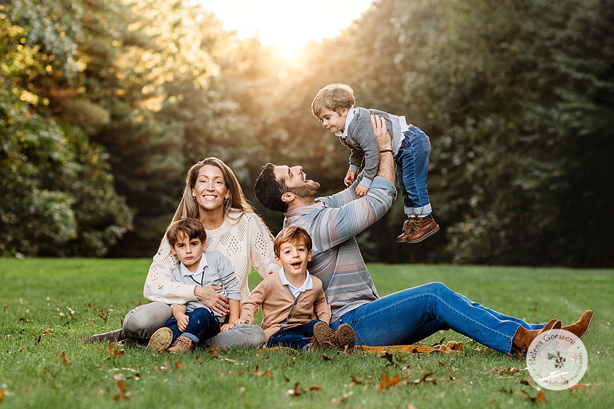 parents sit with three boys on lawn at the Bradley Estate during fall family photos 