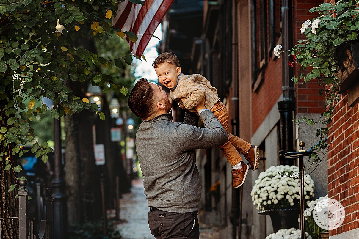 dad lifts up son making him laugh on side street of Beacon Hill MA