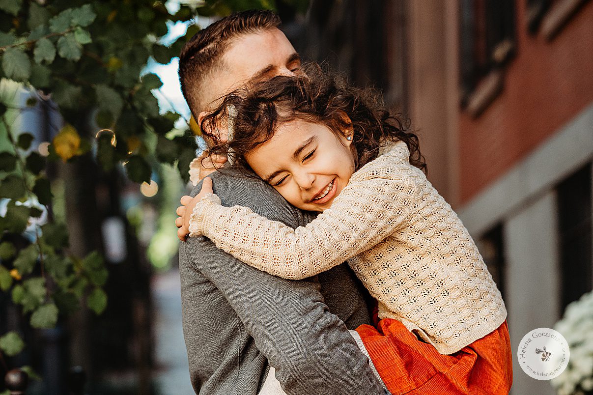 girl hugs dad during family photos on Acorn Street on Beacon Hill in Boston MA 