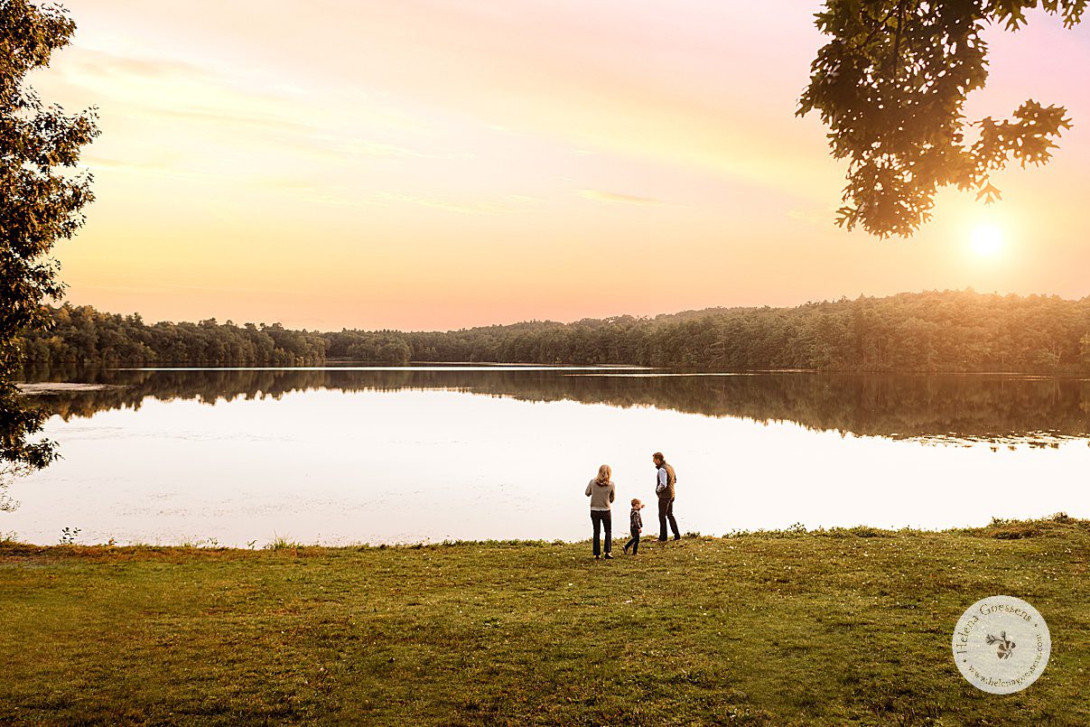 parents walk with toddlers along pond at Wellesley College at sunset in Massachusetts 