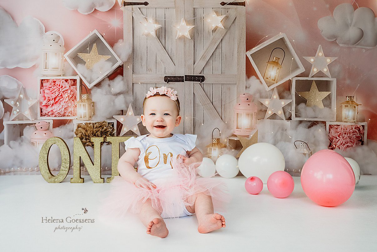 baby girl in pink tutu laughs during first birthday Twinkle Twinkle Little Star cake smash with pink, gold, and white details 