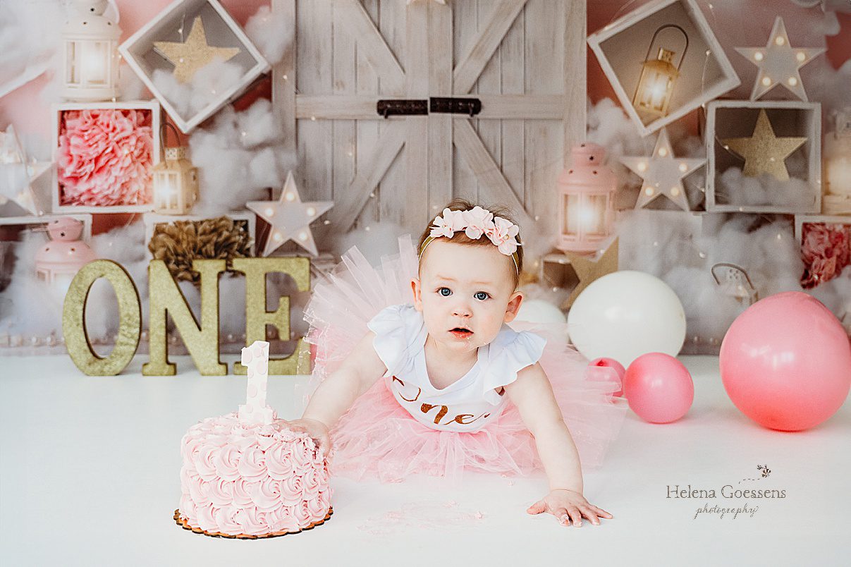 baby in pink tutu with pink headband crawls on floor by cake during first birthday Twinkle Twinkle Little Star cake smash with pink, gold, and white details 