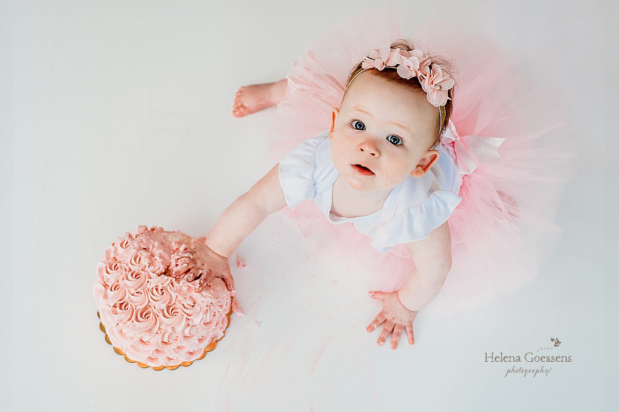 baby girl in pink tutu reaches for cake during first birthday Twinkle Twinkle Little Star cake smash with pink, gold, and white details 