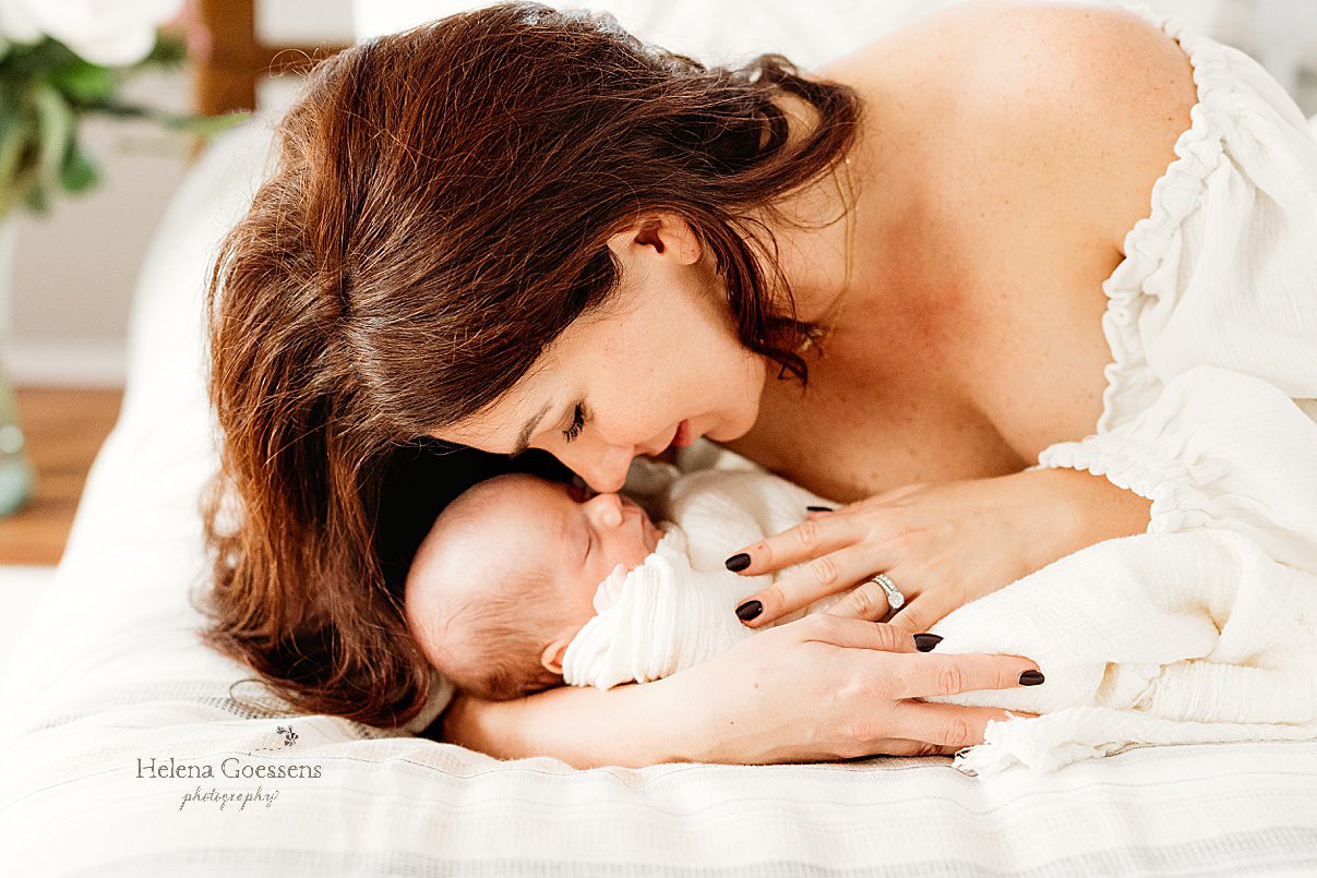 mom leans down to nuzzle newborn son's nose during lifestyle newborn portraits in Waltham MA