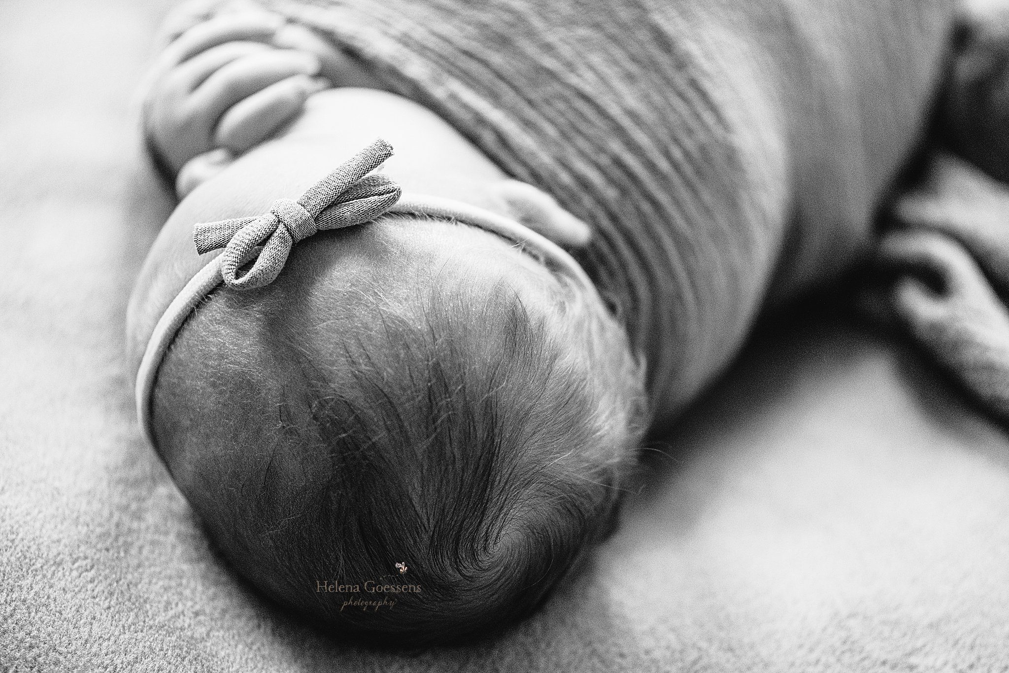 close up of baby's bow on head during at home newborn portraits in Canton MA
