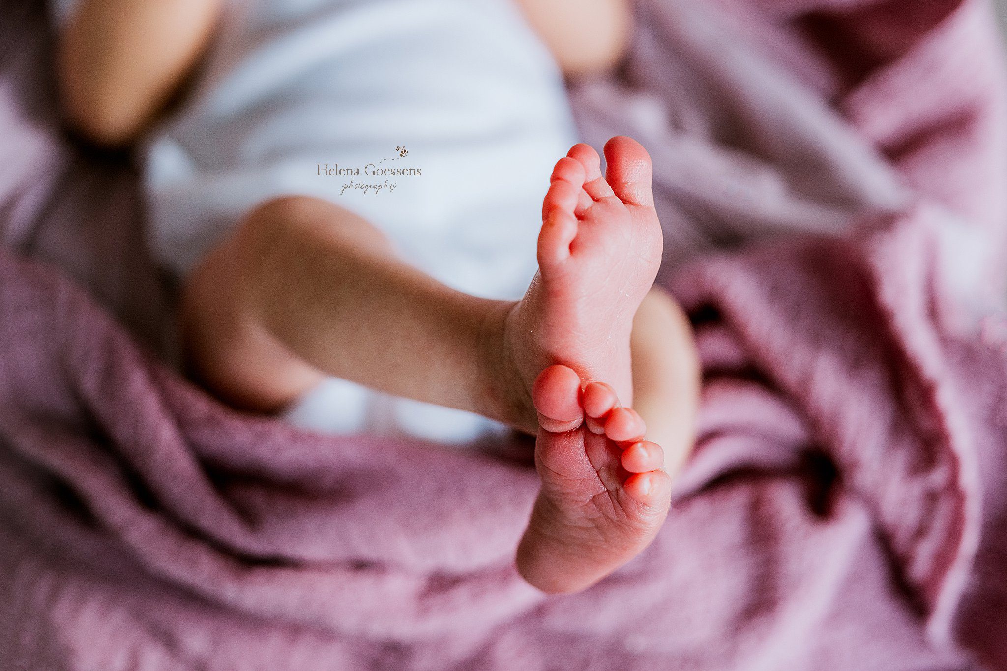 baby's feet stick out of blanket during at home newborn portraits in Canton MA