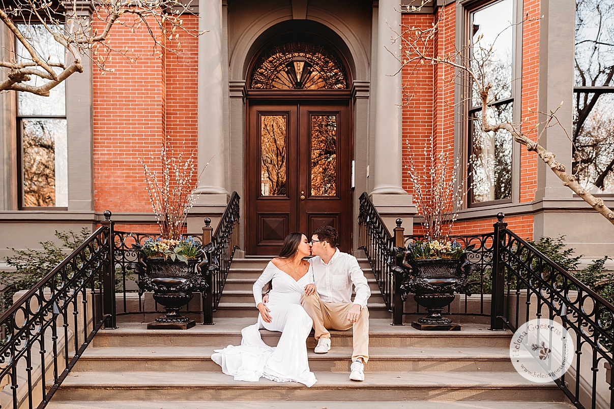 expecting couple sits on steps of brick home on Commonwealth Avenue in Boston MA