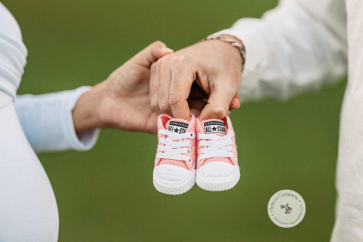 couple holds knit pink converse shoes during Boston Back Bay maternity portraits