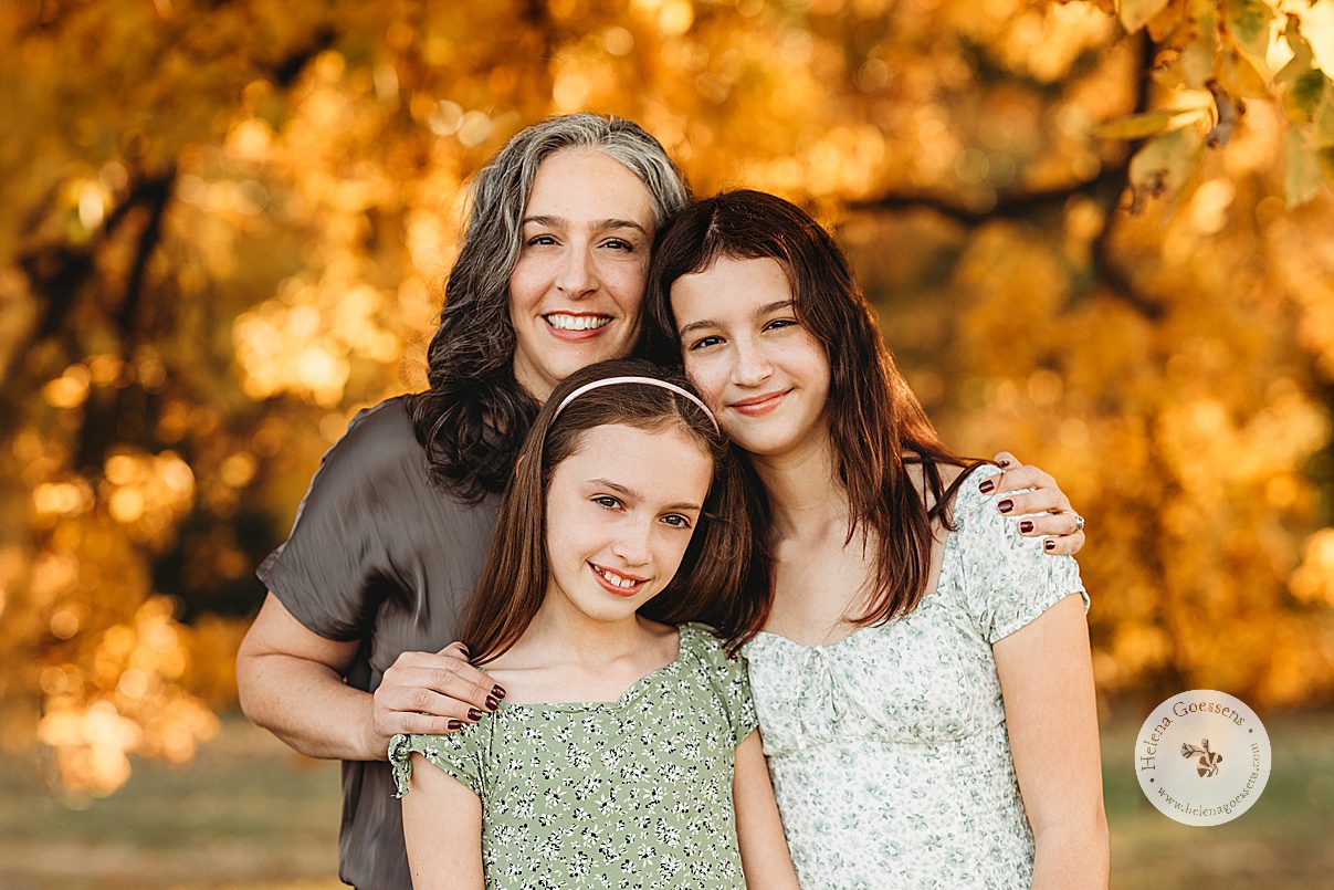 mom hugs two daughters during family portraits at Larz Anderson Park